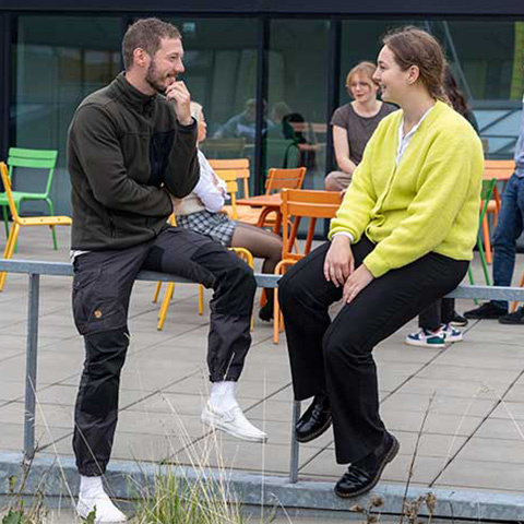 En mandlig og kvindelig studerende taler sammen udenfor på VIAs Campus Aarhus C