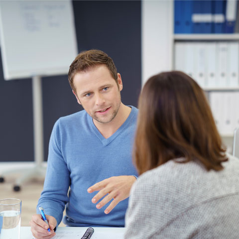 To personer som snakker ved et bord
