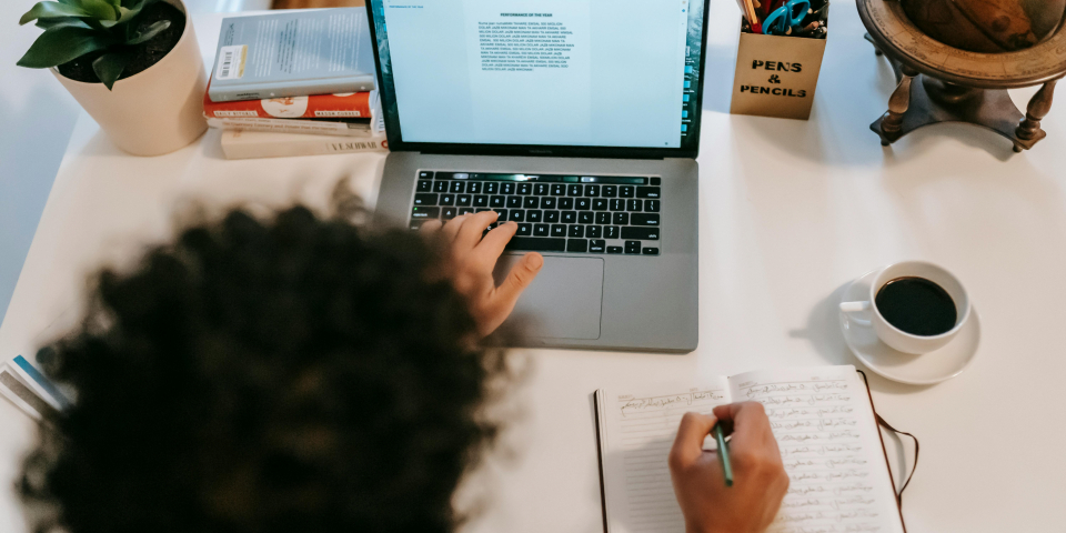 Barn sidder og skriver på computer