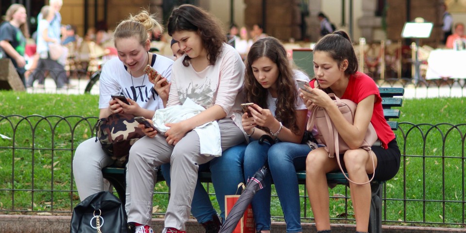 Fire piger med mobiltelefon