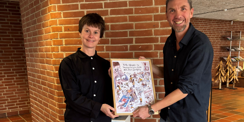 Kasper Lasthein Madsen står med Helle Marie Skovbjerg og holder VIAs idræts- og bevægelsespædagogiske pris 2025.