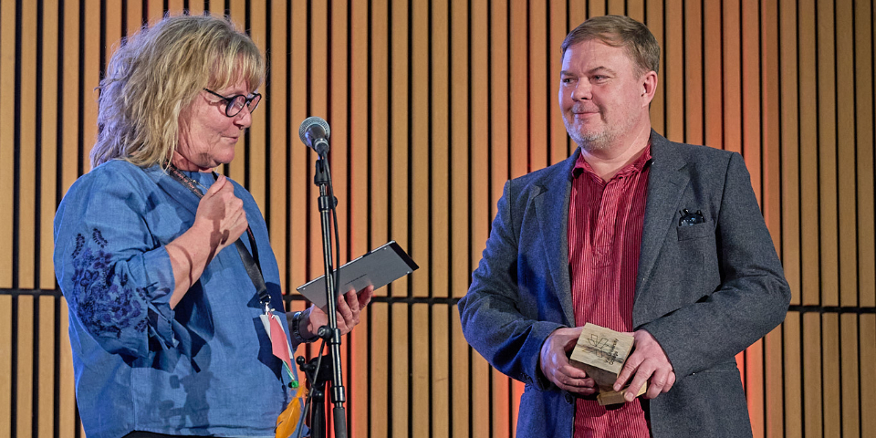 Prorektor Helle Kruuse Andersen overrækker VIA Undervisningsprisen 2025 til lektor Rasmus Henrik Larsen fra læreruddannelsen i Aarhus