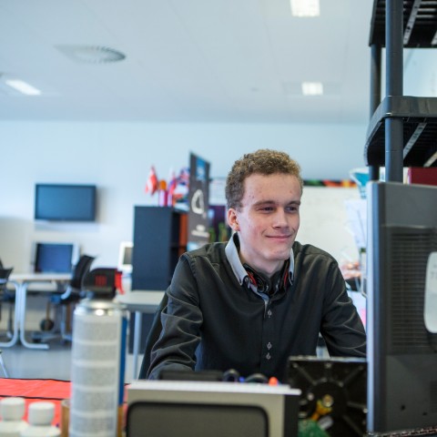 Entreprenant studerende sidder foran sin computer og arbejder