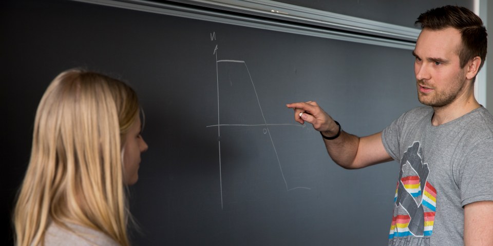 Underviser viser elev tegning på tavlen
