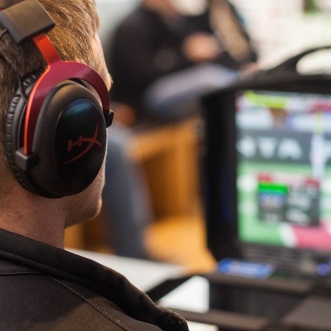 Dreng med hovedtelefoner sidder ved computer