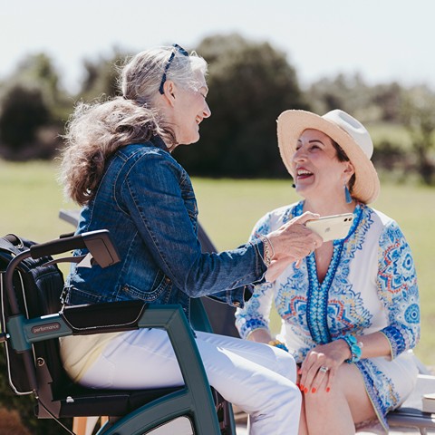 En dame i kørestol snakker med en anden dame