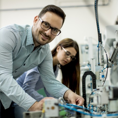 En mand og en kvinde arbejder sammen om at opbygge en produktionslinje