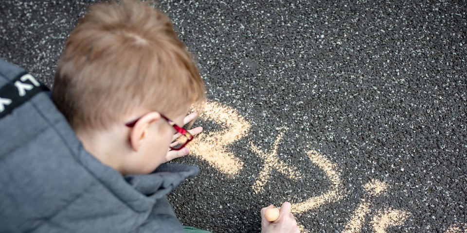 Dreng tegner med kridt