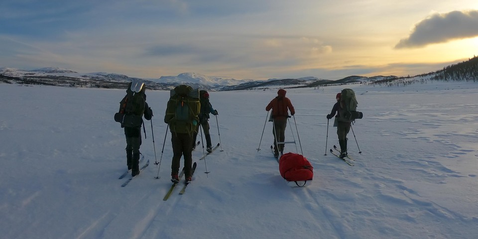 Fem friluftsvejledere er på ski med oppakning i vinterlandskabet