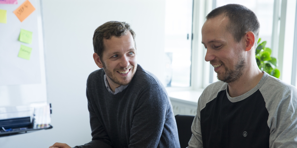 To smilende mænd til workshop. Noter på post-it, sticky notes, flipover