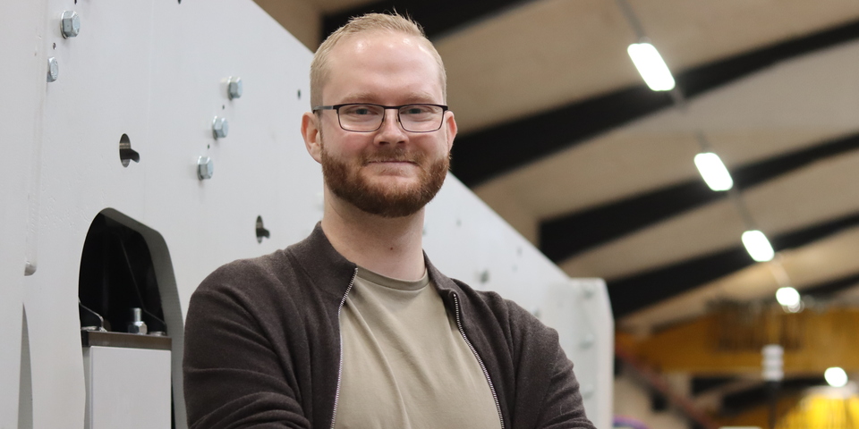 Dimittend Mickey Hornbek-Knudsen står i maskinrummet på sin arbejdsplads