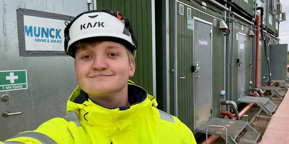 Emil Mortensen på arbejde på en byggeplads iført sikkerhedshjelm og gul jakke.